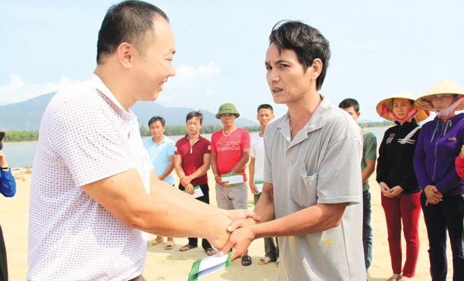 Cứu trợ kịp thời, tận tay người bị thiệt hại Ông Ngô Tuấn Toàn, đại diện lãnh đạo Cty Cổ phần Tập đoàn Phúc Sơn trao quà cho ngư dân bị hư hại tàu cá. Ảnh: Trường Phong.