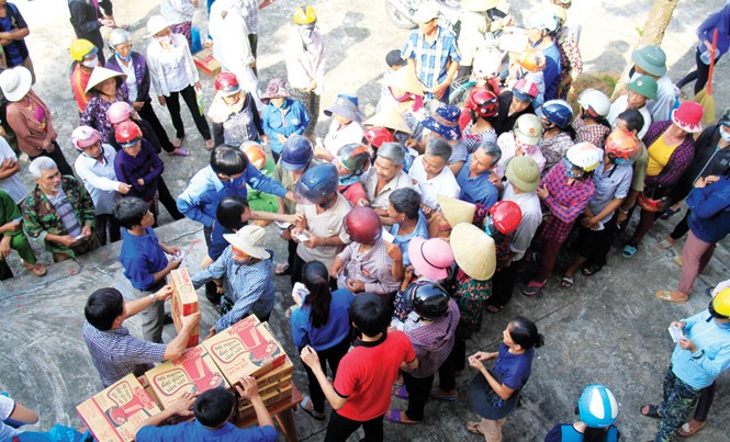 Hậu cứu trợ lũ lụt miền Trung: Khi trưởng thôn đứng ra điều phối Bà con vùng rốn lũ Quảng Bình nhận quà cứu trợ. Ảnh: Trường Phong.