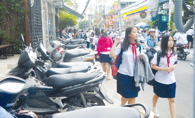 'Cuộc chiến' đòi vỉa hè cho người đi bộ tại TPHCM: Đi bộ ở đâu? Tại TPHCM, vỉa hè bị chiếm làm nơi đậu xe khiến người đi bộ bị dồn xuống lòng đường. Ảnh: PV.