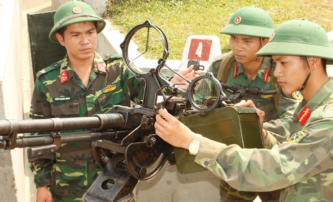 Sỹ quan trẻ toàn diện Thượng uý Đặng Quang Trung (ngoài cùng bên trái) hướng dẫn các pháo thủ bắn súng máy phòng không 12,7mm.