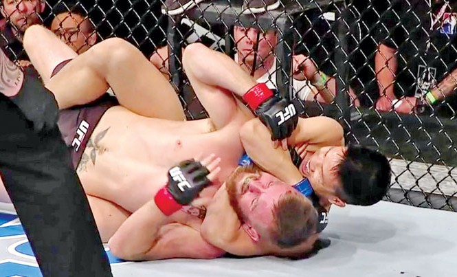 Võ sĩ gốc Việt gây chấn động võ đài MMA Đòn khóa cổ của Ben Nguyen buộc Tim Elliott xin hàng chỉ sau 49 giây. Ảnh: GETTY IMAGES.