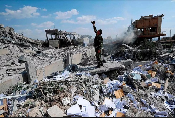 Từ chối trừng phạt Nga, ông Trump khiến cấp dưới bị hớ Một người lính Syria khảo sát đống đổ nát của một cơ sở nghiên cứu khoa học sau khi Mỹ, Anh và Pháp không kích hôm 14/4. Ảnh: AP