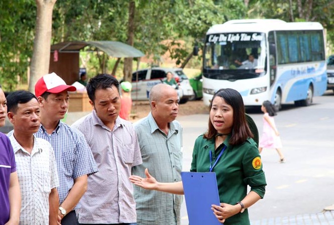 Những người giữ “lửa” ở Ngã ba Ðồng Lộc Chị Lương Thị Thủy đang thuyết minh về di tích hố bom cho đoàn khách tham quan.Ảnh: V.B.