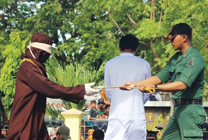 Quan hệ đồng tính, ngoại tình bị phạt roi giữa phố Cảnh phạt roi ở Banda Aceh. Ảnh: CNN.