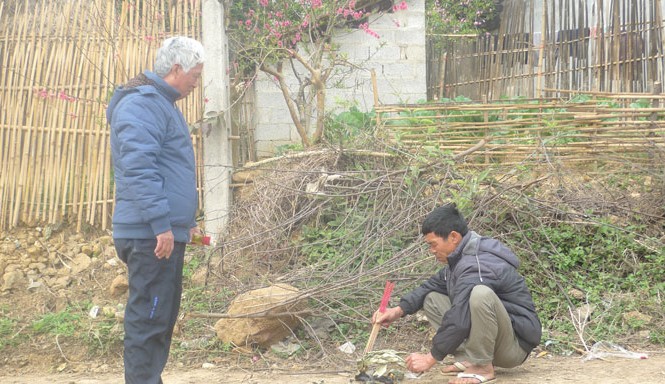 Ký ức khó phai về ngày 17/2/1979 Bác sỹ Đại (bìa trái) và người dân làng Khuổi Mươi thắp nhang tưởng nhớ đến các chiến sỹ áo trắng đã hy sinh vì quê hương (ảnh chụp chiều ngày 16/2/2016). Ảnh: Duy Chiến
