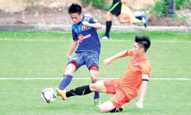 'Hot boy' U19 nguy cơ lỡ giải U20 thế giới Trung vệ trẻ Trọng Đại (phải) đối đầu với đàn anh Văn Quyết trong một buổi đấu tập giữa U19 và ĐTVN. Ảnh: VSI
