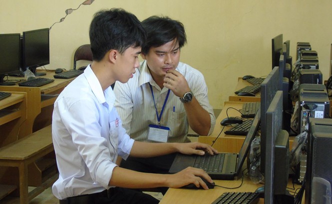 Học sinh trường làng sáng chế máy điểm danh Em Phú được thầy Hưng hướng dẫn lập trình phần mềm. Ảnh: Kim Hà.