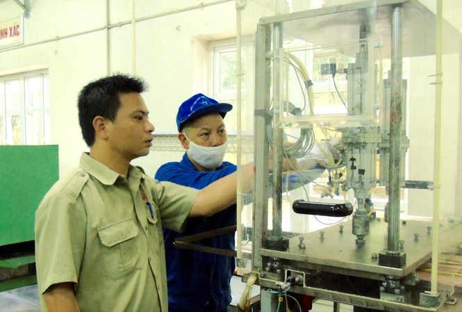 Cống hiến tài năng, lan tỏa yêu thương Kỹ sư Nguyễn Tiến Hưng (trái) kiểm tra thiết bị sản xuất sản phẩm quốc phòng tại Xí nghiệp II . Ảnh: PV