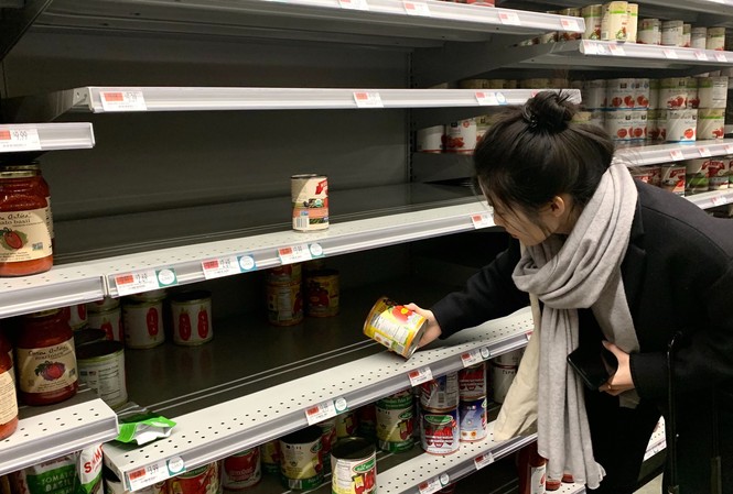 Mỹ: Nhà máy tăng ca để lấp đầy siêu thị mùa dịch Một khách hàng đang chọn mua hộp sốt cà chua tại cửa hàng tạp hóa Whole Food ở thành phố New York. Ảnh: Alex Fang