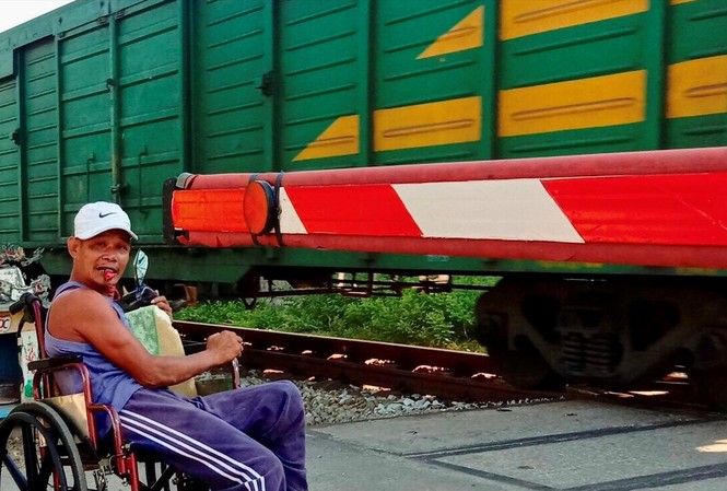Người gác chắn tàu đặc biệt Dù tàn tật, đi lại bằng xe lăn nhưng ông Nguyễn Đức Toàn vẫn tự nguyện làm công việc gác chắn đường ngang nhiều năm nay