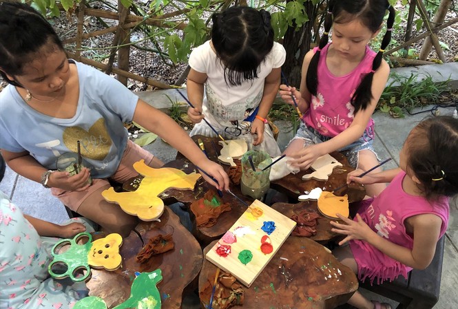 Tìm niềm vui từ workshop Các bé say sưa vẽ màu trên gỗ tại workshop “Xưởng mộc của bé” Ảnh: PV