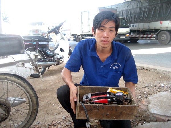 Thanh niên tình nguyện vá xe Nguyễn Nhật Tân và bộ đồ nghề. Ảnh: Q.M