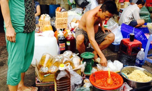 Dầu ăn không rõ nguồn gốc bán từ hẻm ra chợ Các loại dầu ăn trôi nổi, không nhãn mác, thậm chí là bọc trong túi nilon được bày bán nhiều tại các chợ ở Hà Nội, TP HCM. Ảnh: Thi Hà