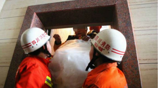 Uyên ương méo mặt vì đám rước dâu bị kẹt thang máy Cô dâu được lực lượng cứu hỏa đỡ xuống khỏi thang máy bị kẹt. Ảnh: CEN.