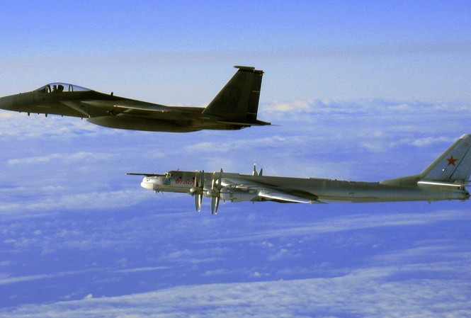 Những mẫu máy bay trứ danh của Không quân Nga Tu-95 (phải) được một chiến đấu cơ F-15C Eagle của Mỹ tháp tùng khi bay gần Alaska. (Ảnh: AP)