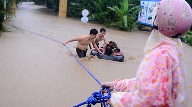 20 bé mẫu giáo thoát chết trong lũ quét Các thanh niên địa phương hỗ trợ đưa cô và trò Trường Mẫu giáo An Hiệp (thôn Mỹ Phú 2) ra khỏi nơi bị ngập.