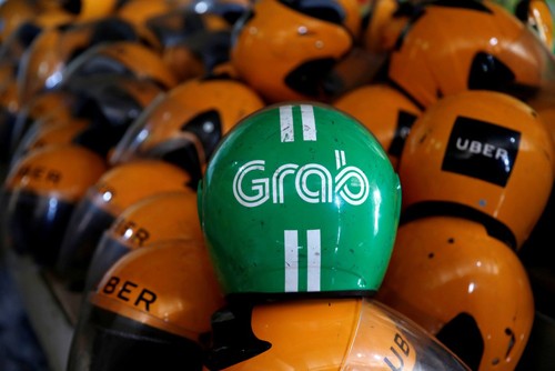 Ngành thuế yêu cầu Grab cung cấp hồ sơ vụ mua lại Uber Mũ bảo hiểm đã sử dụng của tài xế Uber, Grab trong một cửa hàng ở Jakarta, Indonesia. Ảnh: Reuters.