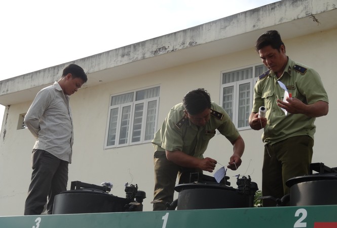 Bắt quả tang một ô tô chở 6.000 lít xăng không rõ nguồn gốc Lực lượng chức năng kiểm tra số hàng hóa có dấu hiệu vi phạm. Ảnh: Cục QLTT Hậu Giang