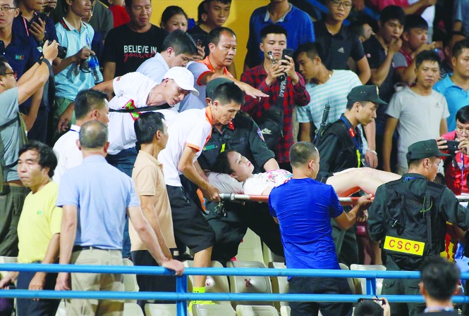 CLB Hà Nội đối diện án 'treo sân' đến hết mùa sau vụ bắn pháo sáng Nữ cổ động viên được đưa lên cáng đi cấp cứu sau khi bị trúng pháo sáng vào đùiảnh: VSI