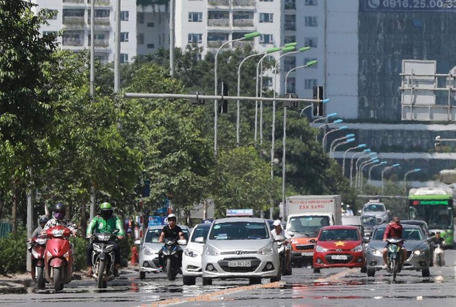 Người dân hãi hùng phơi nắng trên con đường nóng nhất Thủ đô Tuyến đường Lê Văn Lương nắng thiêu đốt đến nỗi mặt đường như bốc hơi, xuất hiện ảo ảnh.