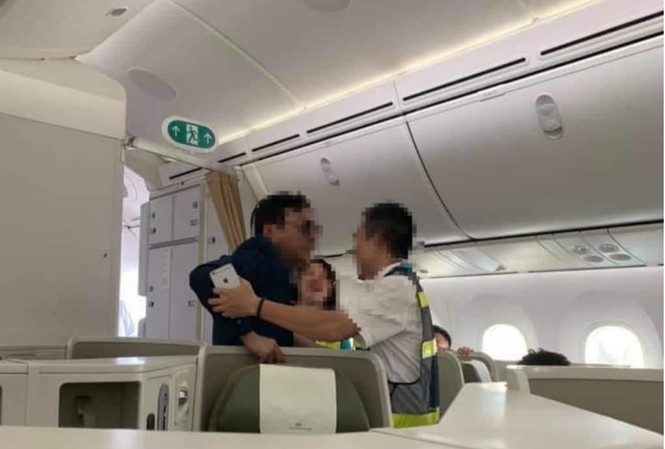 Yêu cầu làm rõ việc 'để lọt' khách say lên máy bay sờ soạng cô gái Ông Vũ Anh Cường (áo đen) bị lực lượng an ninh sân bay đưa khỏi chuyến bay sau hành vi sờ soạng khách nữ khác cùng khoang.