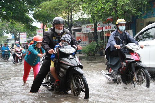 1,7 triệu học sinh Sài Gòn được nghỉ ngày mai Một gia đình TP HCM đưa con đi học trong cơn mưa ở TP HCM. Ảnh minh họa: Mạnh Tùng.
