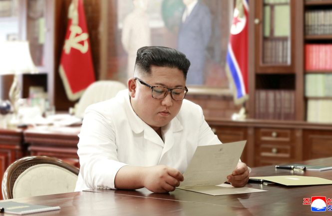 Ông Trump nói có thể sẽ gặp ông Kim ở khu phi quân sự Chủ tịch Triều Tiên Kim Jong-un đọc thư của Tổng thống Mỹ Donald Trump. Ảnh: KCNA