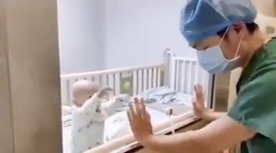 Cha khóc nấc vì không thể bế con 9 tháng tuổi bị cách ly do nhiễm corona Người cha không giấu nổi nước mắt khi con trai giơ tay đòi bế.
