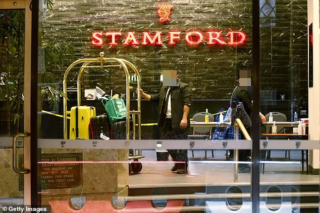 Úc: Số ca COVID-19 tăng vọt nghi do quan hệ bừa bãi trong khách sạn cách ly Nhân viên khách sạn Stamford ở Melbourne (bang Victoria) kéo hành lý cho các du khách bị cách ly. Ảnh: Getty