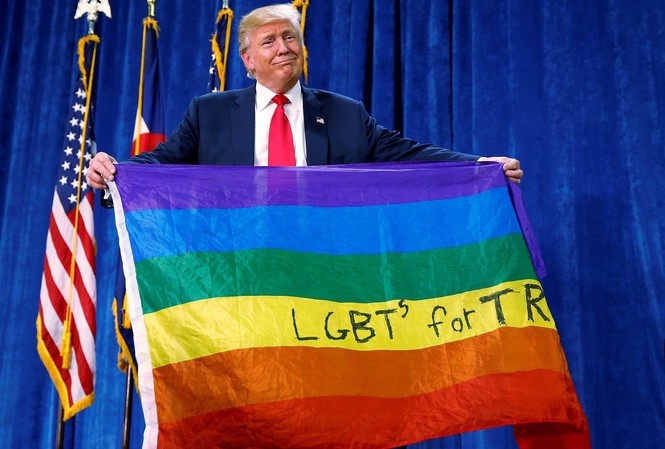 Khảo sát: Người đồng tính nam Mỹ thích ông Biden hơn ông Trump Tổng thống Mỹ Trump cầm lá cờ 7 màu của cộng đồng LGBTQ. Ảnh: Reuters