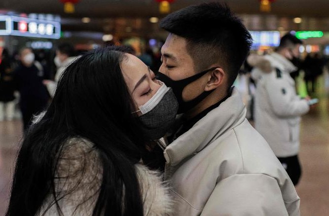 Trung Quốc nói coronavirus có thể lây trước khi người nhiễm có triệu chứng Một đôi uyên ương đeo khẩu trang hôn tạm biệt tại một nhà ga tàu hỏa ở Bắc Kinh. Ảnh: Getty.