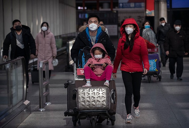 Mỹ có ca lây virus corona từ người sang người, Ý dừng mọi chuyến bay với TQ Hành khách đeo khẩu trang phòng nhiễm virus corona mới ở sân bay thủ đô Bắc Kinh ngày 30/1. Ảnh: Getty.
