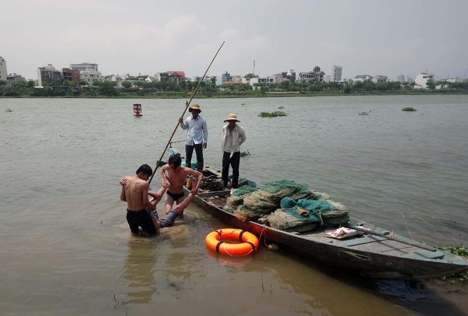 Hai bảo vệ lao xuống sông cứu thanh niên 18 tuổi nhảy cầu tự tử Hai bảo vệ đưa nạn nhân vào bờ sau khi ứng cứu