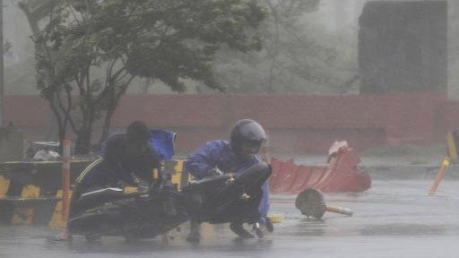 Bão Thần Sấm tấn công Philippines, 10 người chết Người đi xe máy bị bão Thần Sấm quật ngã ở Manila
