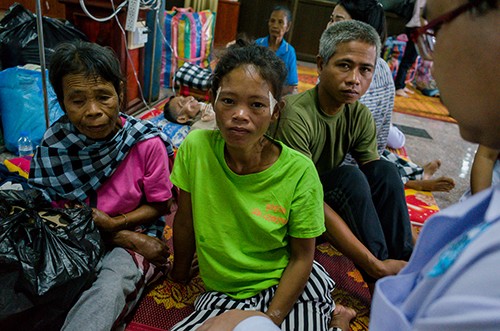 Người cha Lào bất lực nhìn lũ cuốn trôi hai con gái Vợ chồng anh La và chị Aun (đầu tiên và thứ hai từ phải sang) tại trại tạm trú ở thị trấn Attapeu. Ảnh: Thành Nguyễn