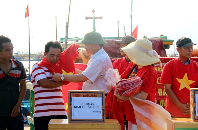 Ngư dân Đà Nẵng đồng loạt ra khơi Ngư dân Đà Nẵng khoác trên người chiếc áo in hình cờ Tổ quốc thể hiện quyết tâm bám biển. Ảnh: Hoài Văn