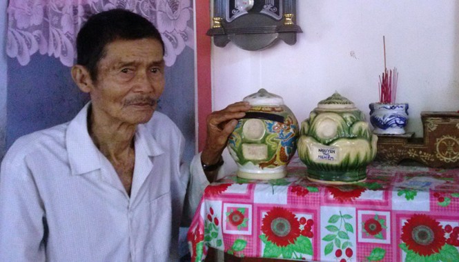 Dân phải bốc hài cốt cha mẹ để trong nhà Ông Huỳnh Văn Châu bên hũ hài cốt của cha mẹ cất trên bàn thờ. Ảnh: Hòa Hội
