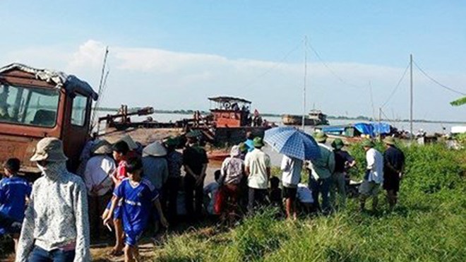 Va chạm với tàu cát, 2 người bị cuốn trôi Lực lượng cứu nạn phối hợp với gia đình các nạn nhân tìm kiếm trên sông Hồng