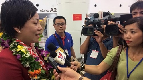 HLV của Hoàng Xuân Vinh vỡ òa cảm xúc ngày về HLV Nguyễn Thị Nhung của đội tuyển bắn súng Việt Nam trả lời phỏng vấn tại sân bay. Ảnh: Nguyên Phong.