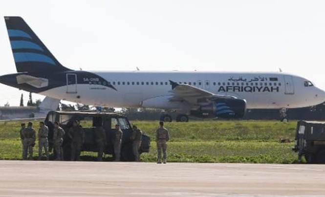 Tin mới nhất về vụ không tặc cướp máy bay Libya Binh sĩ Malta kiểm tra chiếc Airbus A320 trên đường băng sân bay quốc tế Malta. Ảnh: Reuters.