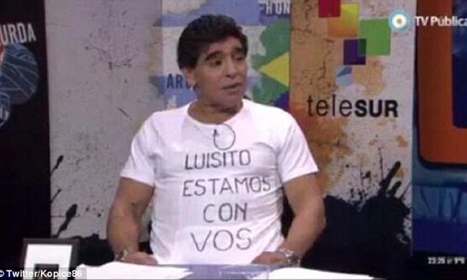 'Sao không còng tay Suarez rồi tống vào tù?' Maradona bày tỏ sự ủng hộ đối với Suarez bằng cách mặc một chiếc áo có dòng chữ: “Luis, chúng tôi ở bên anh”.