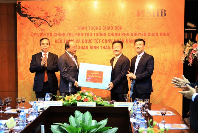 Phó Thủ tướng Nguyễn Xuân Phúc thăm, chúc Tết SHB Ủy viên Bộ Chính trị, Phó Thủ tướng Nguyễn Xuân Phúc tặng quà cho Ngân hàng SHB.