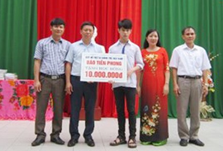 Trao học bổng cho học sinh nghèo vượt khó Ông Trần Thanh Lâm, Phó Tổng Biên tập Báo Tiền Phong, Phó giám đốc Quỹ hỗ trợ tài năng trẻ Việt Nam cùng đại diện lãnh đạo địa phương, nhà trường trao tặng học bổng cho em Lê Đức Hậu. Ảnh: Hoàng Lam