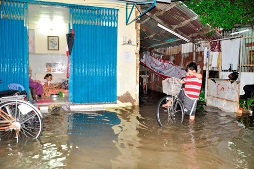 Bộ Xây dựng tìm giải pháp chống ngập cho TPHCM Người dân bất lực nhìn nước ngập tràn vào nhà. Ảnh: Ngô Bình
