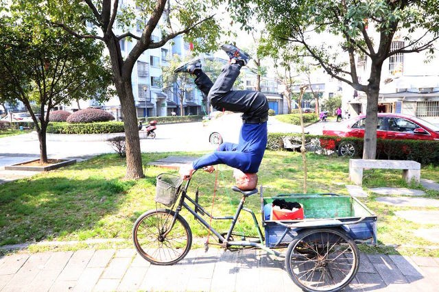 Người đàn ông 'trồng cây chuối' điều khiển xe ba bánh Ông Zhu vừa "trồng cây chuối" vừa điều khiển xe 3 bánh.