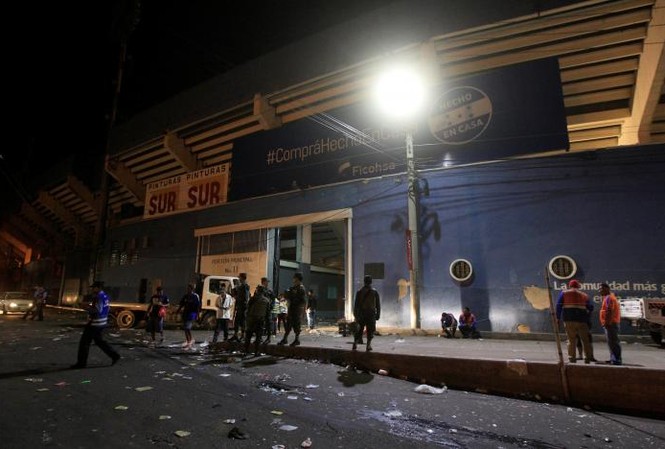 'Vỡ trận’ trên sân vận động Honduras, 19 người thương vong Cảnh sát đứng bên ngoài sân vận động sau sự cố hàng trăm người cố gắng vượt rào vào xem bóng đá ở Tegucigalpa. Ảnh: Reuters