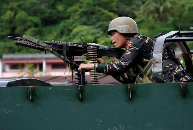Quân đội Philippines tái chiếm Marawi, tạo cơ hội cho phiến quân đầu hàng Một binh sĩ Philippines trên xe chiến đấu bọc thép ở thành phố Marawi ngày 28/5. Ảnh: Reuters