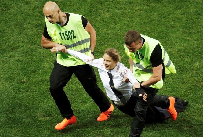 Nhóm nhạc náo loạn chung kết World Cup bị phạt tù 15 ngày Một thành viên Pussy Riot bị cưỡng chế rời sân thi đấu chung kết World Cup.