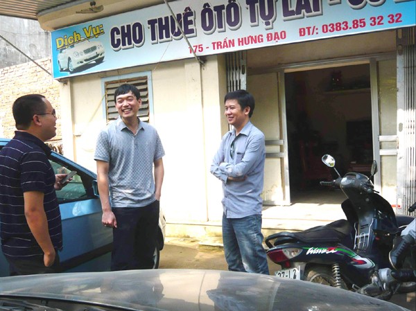 Xuất ngoại làm thuê, về quê làm ông chủ Anh Thành (giữa) đang trao đổi với khách hàng có nhu cầu thuê xe. Ảnh: P.C