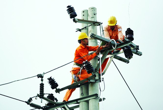 Điện thừa, vốn thiếu Công nhân điện lực đang thi công mạng lưới điện tại cầu Vĩnh Tuy (Hà Nội). Ảnh: Xuân Phú